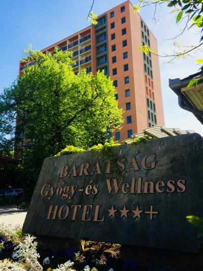 Hotel cégtábla háttérben az épülettel