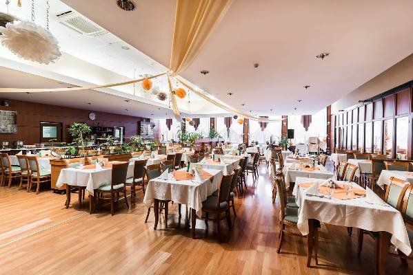 Megterített éttermi asztalok, feldíszített Barátság terem